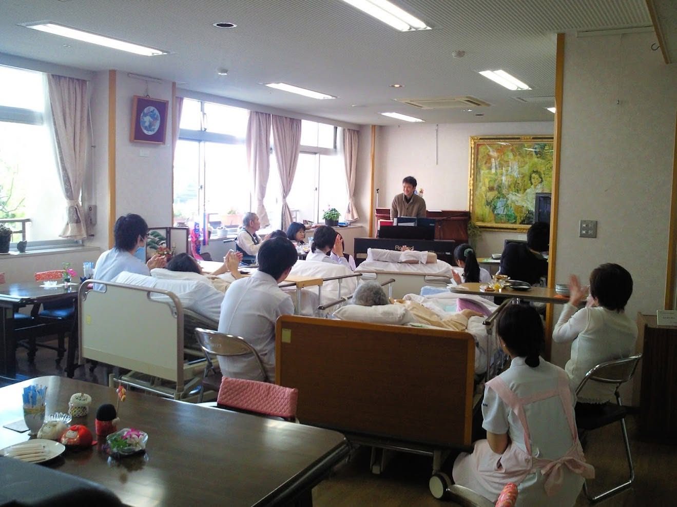 ホスピスの「ひまわり喫茶」で、ベッドのまま参加されるみなさんの前で演奏する弓削田健介