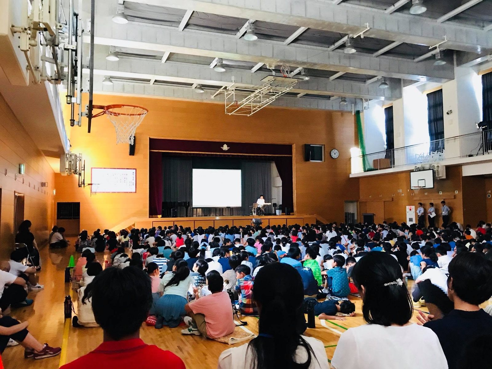 体育館いっぱいの子どもたちがステージの語りに耳を傾ける学校公演の様子