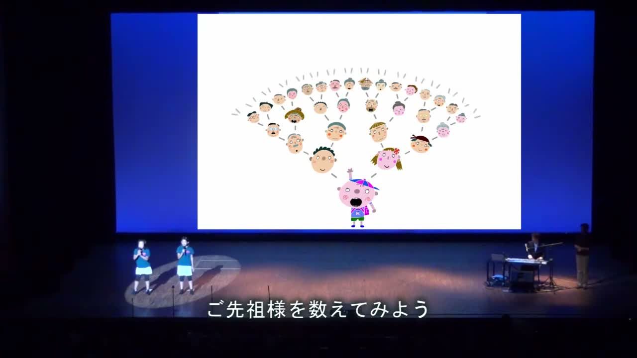 スクリーンいっぱいに映されたご先祖さまを数える場面と、ステージで歌う子どもたち
